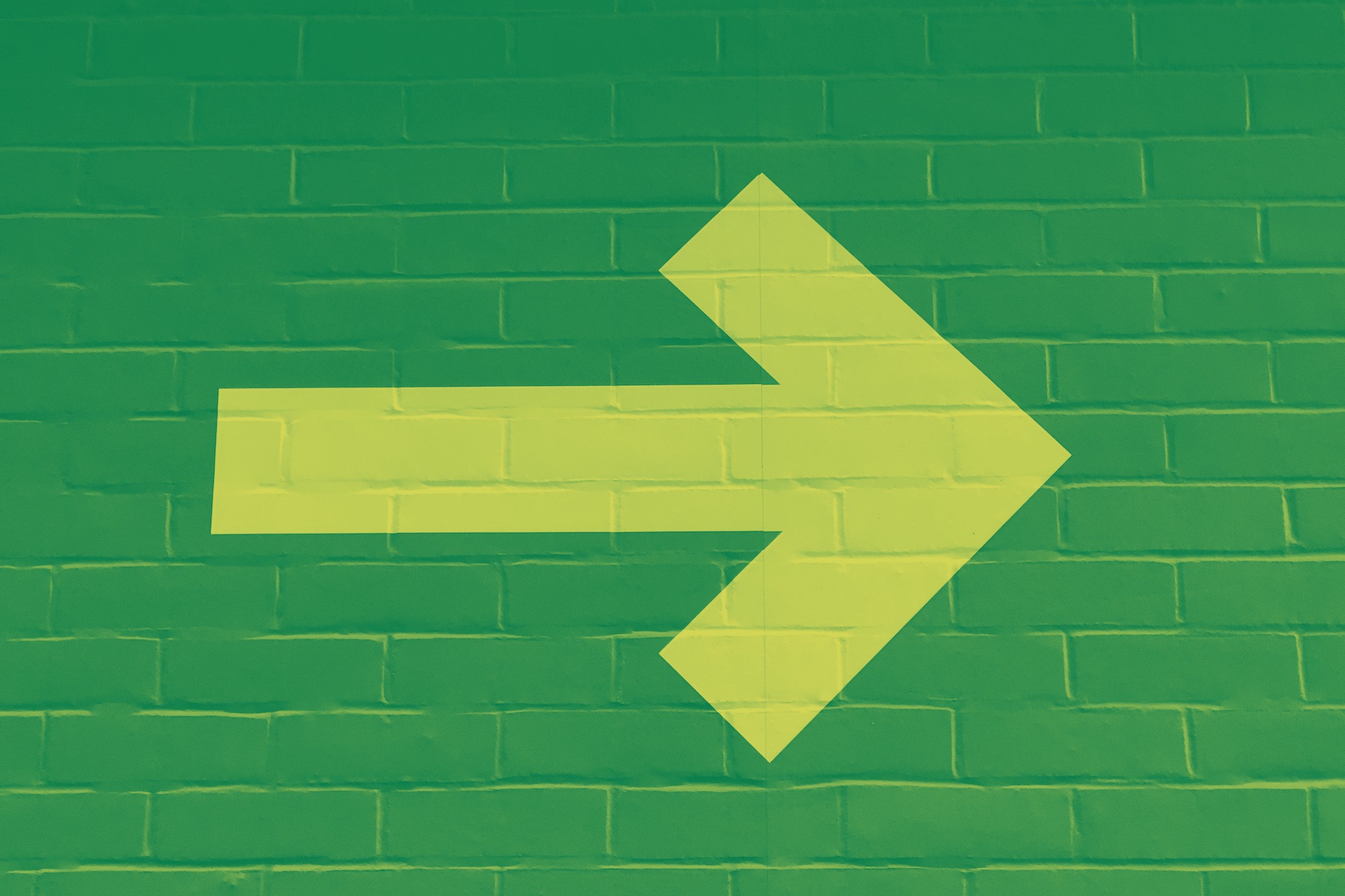 A yellow arrow pointing toward the right, against a green background.